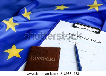 Visa application form for immigration, passport and pen on European Union flag, closeup