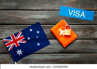 Visa To Australia Concept. Australian Flag Near Passport And Lock On Dark Wooden Background Top-down