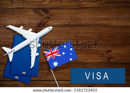 Visa to Australia concept. Text visa near passport cover and australian flag, hammer on dark wooden background top view copy space