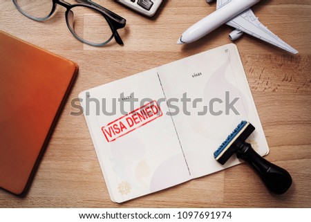 visa and passport with denied stamp on a document top view in immigration. travel immigration stamp and tourism concept