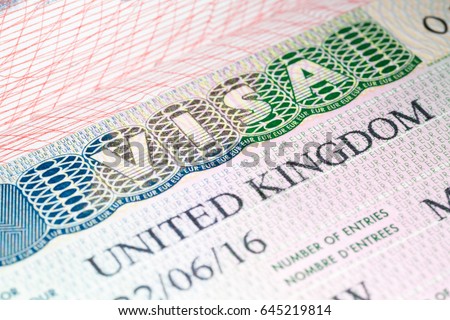 Visa to UK. United Kingdom visa vignette in passport. Macro image, selective focus