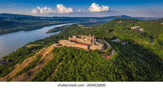 Visegrad, Hungary - Aerial panoramic drone view of the beautiful high castle of Visegrad with summer foliage and trees. Dunakanyar and blue sky with clouds at background - Shutterstock ID 2054526830