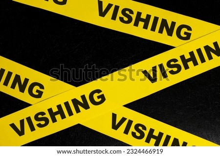 Vishing scam alert, caution and warning concept. Yellow barricade tape with word vishing in dark black background.