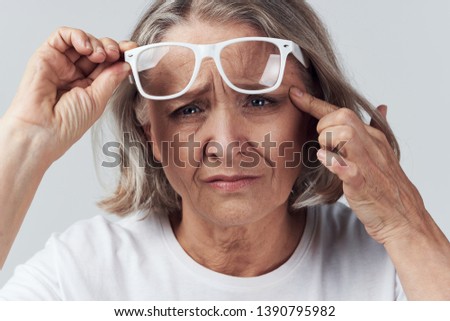 Vision problems elderly woman short hair white jersey fashionable glasses           