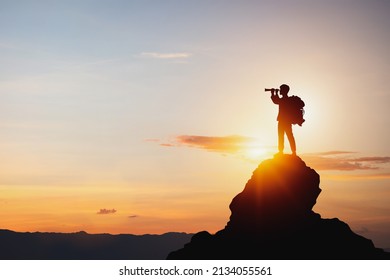 vision for success ideas. businessman's perspective for future planning. Silhouette of man holding binoculars on mountain peak against bright sunlight sky background. - Powered by Shutterstock