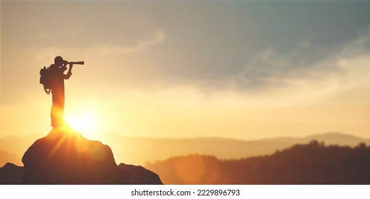 vision for success ideas. businessman's perspective for future planning. Silhouette of man holding binoculars on mountain peak against bright sunlight sky background. - Shutterstock ID 2229896793