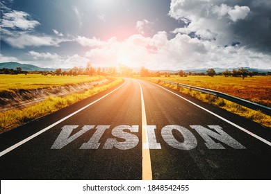 VISION Written On Highway Road In The Middle Of Empty Asphalt Road At Golden Sunset And Beautiful Blue Sky. Vision Concept.