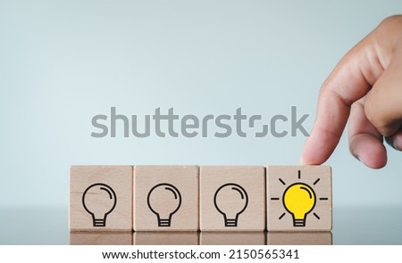 Vision,Idea,Inspiration and innovation of BusinessConcept.,Man Choose turning on light bulb icon on wooden cube.