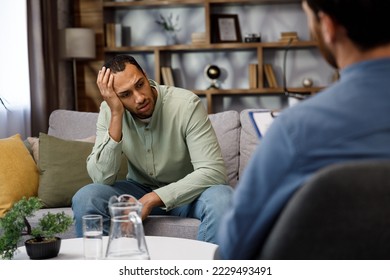 A visit to an African American psychologist. A man sits on a couch and talks to a psychotherapist. Depression, apathy, stress, burnout at work. Help of a psychologist.