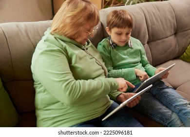 Visit Grandparent. Middle Age Woman And School Age Boy, Granny And Grandson Sitting At Home And Talking, Having Fun. Concept Of Emotions, Family, Happiness, Care, Support And Leisure Activities