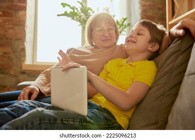 Visit Grandparent. Middle Age Woman And School Age Boy, Granny And Grandson Sitting At Home And Talking, Having Fun. Concept Of Emotions, Family, Happiness, Care, Support And Leisure Activities