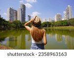 Visiting Goiania, Brazil. Back view of young woman in Parque Sulivan Silvestre also known as Parque Vaca Brava, a city park in Goiania, Goias, Brazil.