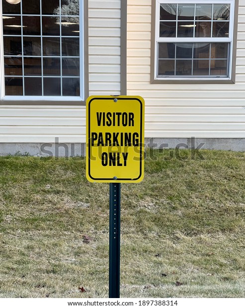 Visitor center parking only sign displayed in a\
parking lot