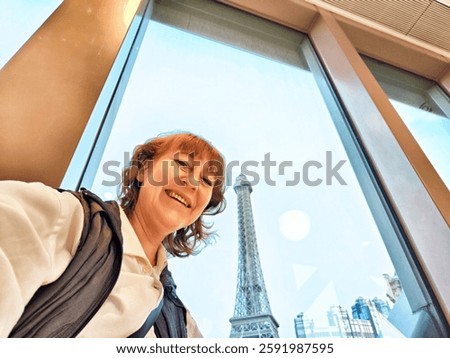 A visitor smiles while capturing a selfie with the stunning Eiffel Tower replica in Macau's casino district.