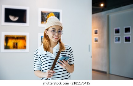 Visitor woman standing takes picture art gallery collection in front framed paintings pictures with mobile phone, Asian female watching at photo frame with smartphone at artwork gallery show - Shutterstock ID 2181175415