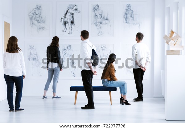 Visitors in art gallery with\
drawings and sculpture during cultural meeting. Art gallery concept\
