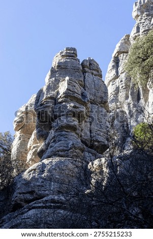 Visitors explore the unique rock formations in El Torcal, Spain. People walk through the area and admire the natural shapes and structures under the clear blue sky.
