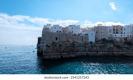 Visitors marvel at the breathtaking cliffs of Puglia, where whitewashed buildings cling to the rocky shores, while gentle waves lap against the ancient stone, Polignano a Mare Italy  - Powered by Shutterstock