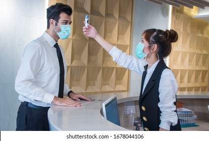 Visitors must go through fever measures using infrared digital thermometer check temperature measurement, fever examination at the building.Measures to prevent people with fever, Covid 19 concept