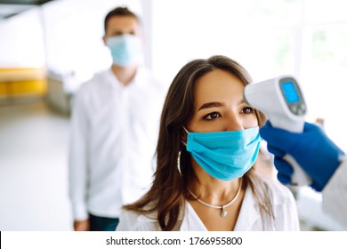 Visitors must go through fever measures using infrared digital thermometer check temperature measurement on the forehead. Covid-19, quarantine or virus outbreak concept. - Powered by Shutterstock