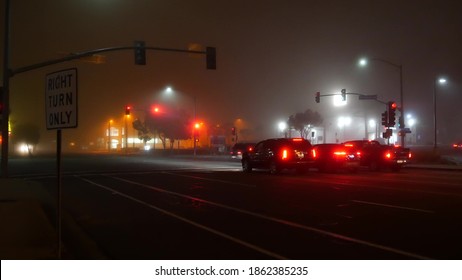 VISTA, CALIFORNIA USA - 24 JAN 2020: Marine Layer, Dense Fog On Driveway Crossroad At Night. June Gloom, Misty Nebulous Bad Weather. Dangerous Low Visibility On Road Intersection. Car Traffic Safety.