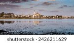 Vista de la Aldea del Rocío al atardecer, con la ermita reflejándose en las marismas de Doñana, Huelva, Andalucía, España