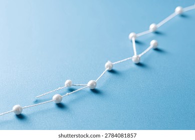 A visual metaphor for progress and interconnectedness, depicted by pearls strung together on a blue background.