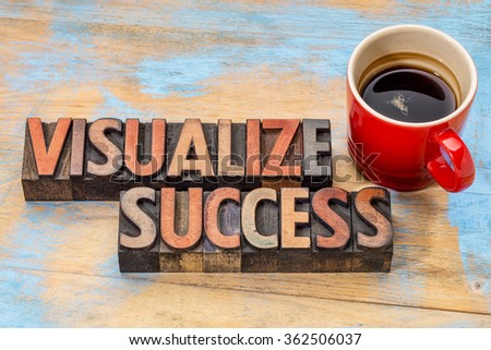 visualize success banner  - text in vintage letterpress wood type blocks stained by color inks against grunge wood with a cup of coffee