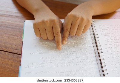 Visually impaired person reads with his fingers a book written in braille It is written for those who are visually impaired or blind. It is a special code generated from 6 dots in the box.             - Powered by Shutterstock