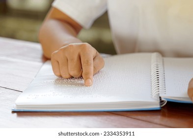 Visually impaired person reads with his fingers a book written in braille It is written for those who are visually impaired or blind. It is a special code generated from 6 dots in the box.             - Powered by Shutterstock