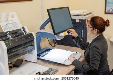 A Visually Impaired Woman Uses Special Reading Equipment