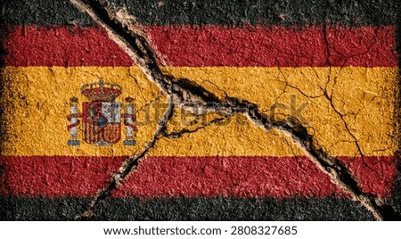 A visually striking image of the Spanish flag fractured by a deep crack, representing political or social division, economic hardship, or national crisis.