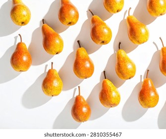 A visually striking pattern of fresh, ripe pears arranged diagonally on a clean white surface, casting distinct, elongated shadows.