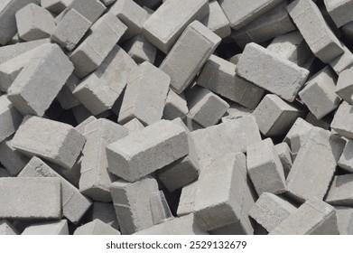 A visually striking stack of concrete blocks, ideal for constructing sturdy walls or elegant patio flooring. Perfect for enhancing the durability and aesthetic of any home project.