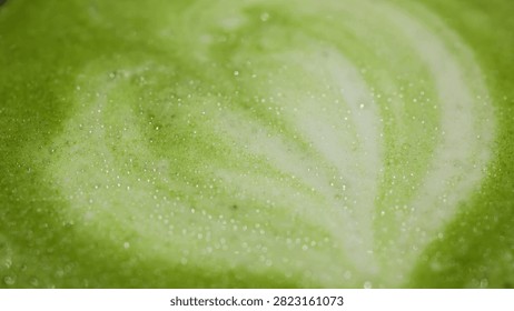 Visuals highlight the process of creating intricate latte art in matcha green tea. Swirls and heart shapes form, showcasing artistry and traditional techniques.