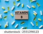 Vitamin B symbol. Concept word Vitamin B on wooden blocks. Beautiful blue background with pills. Medicine and Vitamin B concept. Copy space