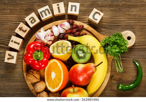 Vitamine C in groenten en fruit. Natuurlijke producten rijk aan vitamine C als sinaasappels, citroenen, gedroogde vruchten roos, rode peper, kiwi, peterselie bladeren, knoflook, bananen, peren, appels, walnoten, chili.