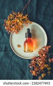 Vitamin C Serum In A Bottle With A Pipette On A Round Dish. The Concept Of Anti-acid Autumn Skincare