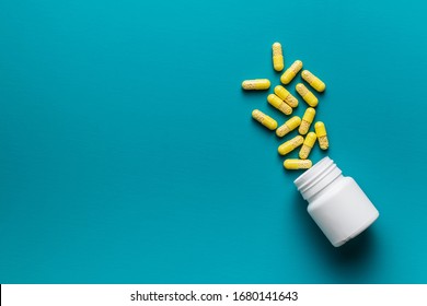 Vitamin capsules. Vitamin C pills and pill bottle on blue background. Top view.