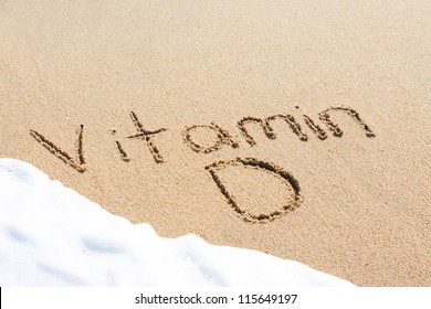 Vitamin D written in the sand with foam from a wave washing up