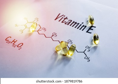 Vitamin E Or Alpha Tocopherols Softgels With Chemical Formula Written On White Background With Selective Focus.