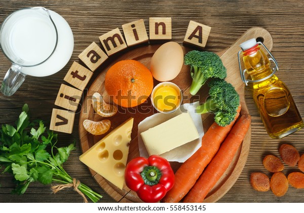 „Vitamine A in voedsel” Natuurlijke producten rijk aan vitamine A als mandarijn, rode peper, peterselie bladeren, gedroogde abrikozen, wortelen, broccoli, boter, gele kaas, melk, eigeel en levertraan.