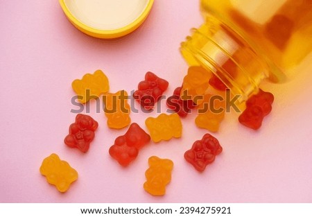 Vitamins for children,   jelly gummy bears candy on pastel pink background