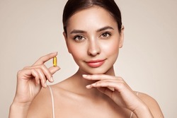 Vitamins. Close Up Of Happy Beautiful Girl With Pill With Cod Liver Oil Omega-3. Nutrition. Vitamin D, E, A Fish Oil Capsules. Healthy Lifestyle. Sport, Diet Concept