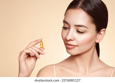 Vitamins. Close Up Of Happy Beautiful Girl With Pill With Cod Liver Oil Omega-3. Nutrition. Vitamin D, E, A Fish Oil Capsules. Healthy Lifestyle. Sport, Diet Concept - Powered by Shutterstock