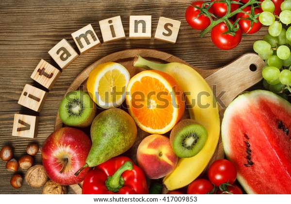 Vitaminen in groenten en fruit. Natuurlijke producten rijk aan vitamines zoals sinaasappels, citroenen, rode peper, kiwi, tomaten, bananen, peren, appels, walnoten, watermeloen, hazelnoten, perzik en groene druif