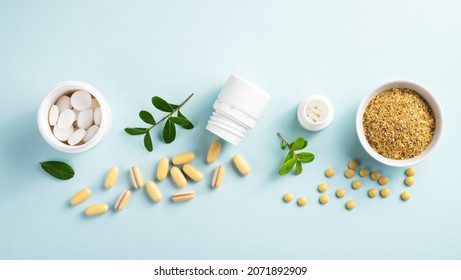 Vitamins and herbal supplements in jars with a green plant on a blue background.Biologically active additives. Dietary supplements.