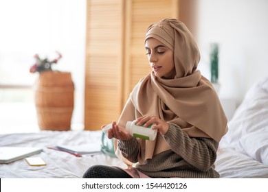 Vitamins For Immunity. Pretty Woman Sitting On The Bed Taking Some Vitamins For Immunity Support