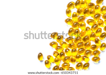 Vitamins pills of yellow color isolated on white background. Cod liver oil. Fish oil capsule pills closeup background