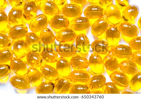 Vitamins pills of yellow color isolated on white background. Cod liver oil. Fish oil capsule pills closeup background
